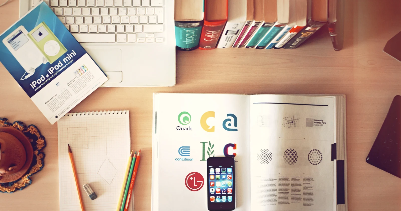 Computer and mobile devices beside books and planning notes