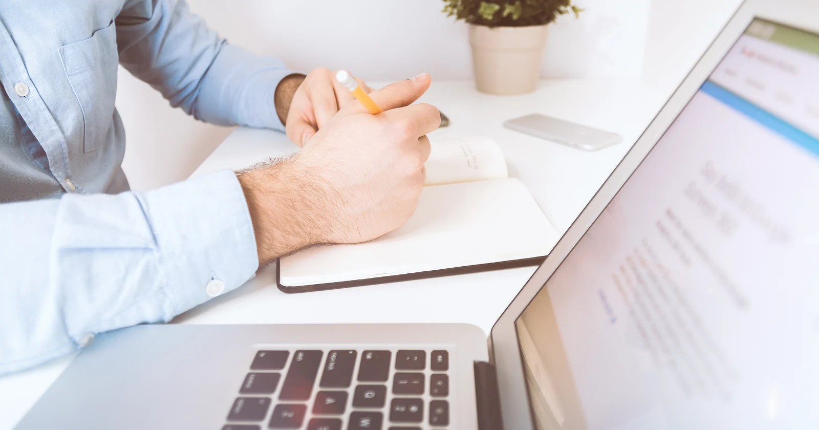 Office worker reviewing notes beside a laptop