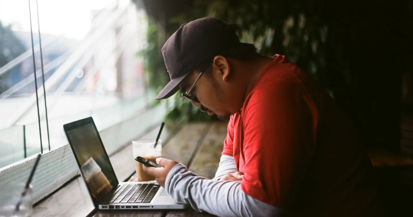 Person working on a laptop beside a window