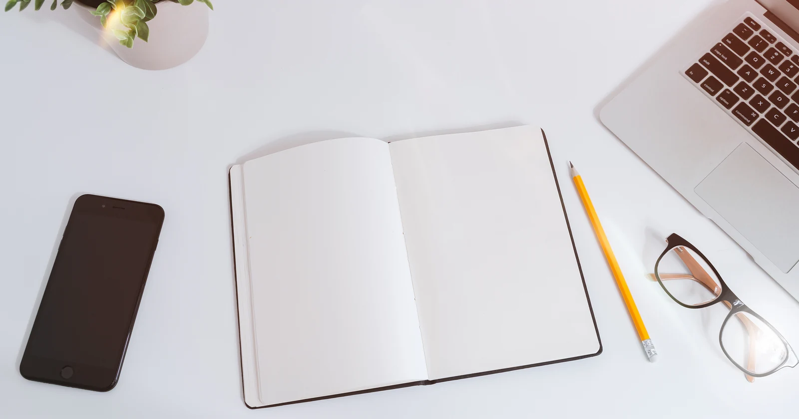 Notebook, smartphone and laptop on a planning desk