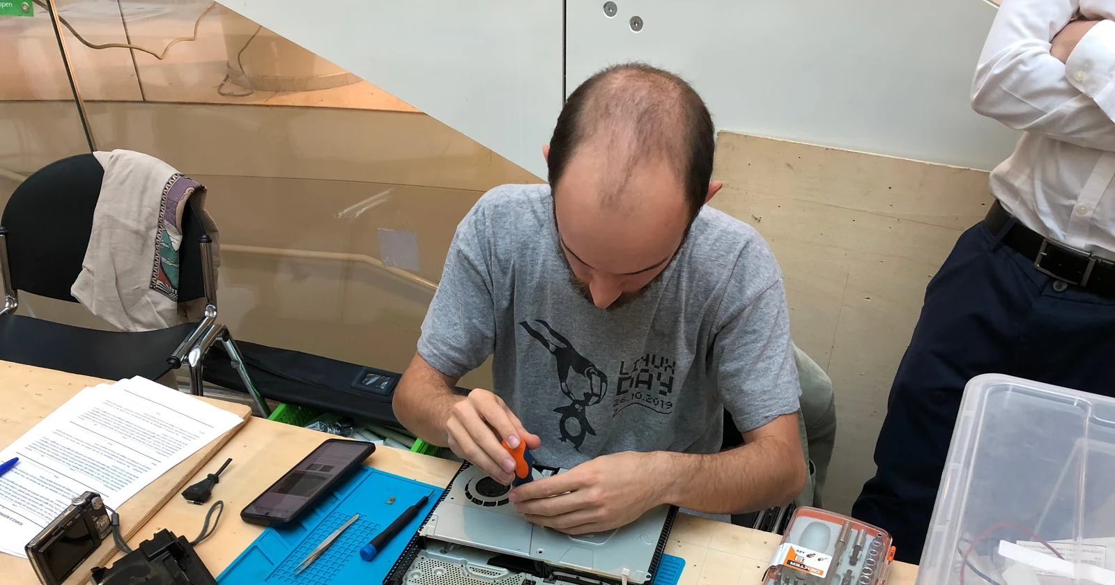 Technician repairing a laptop at a workbench