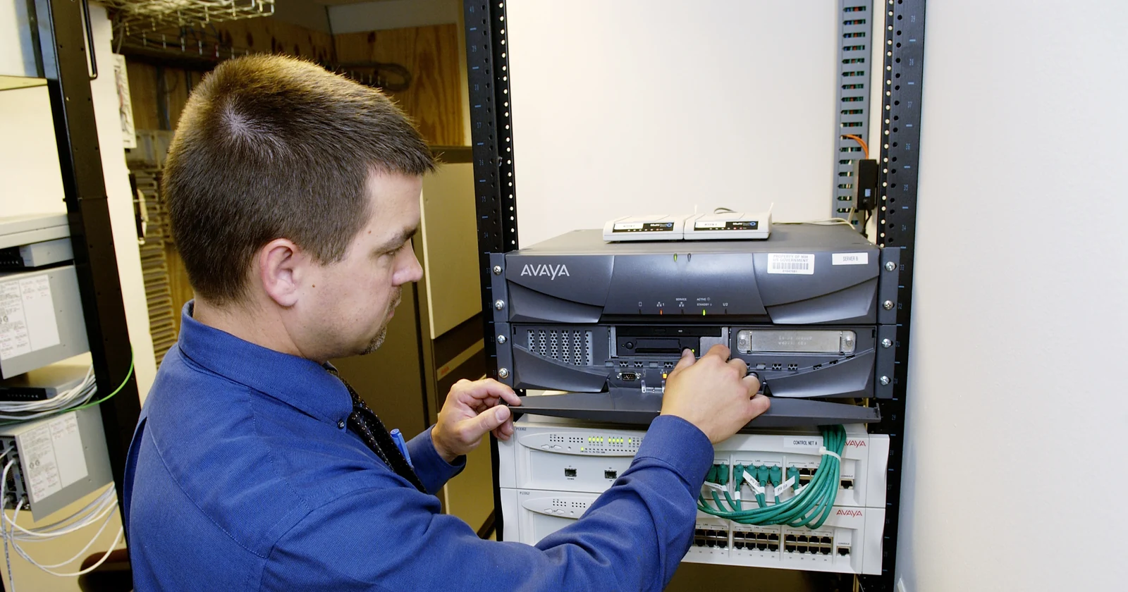 Technician checking equipment inside a network server rack