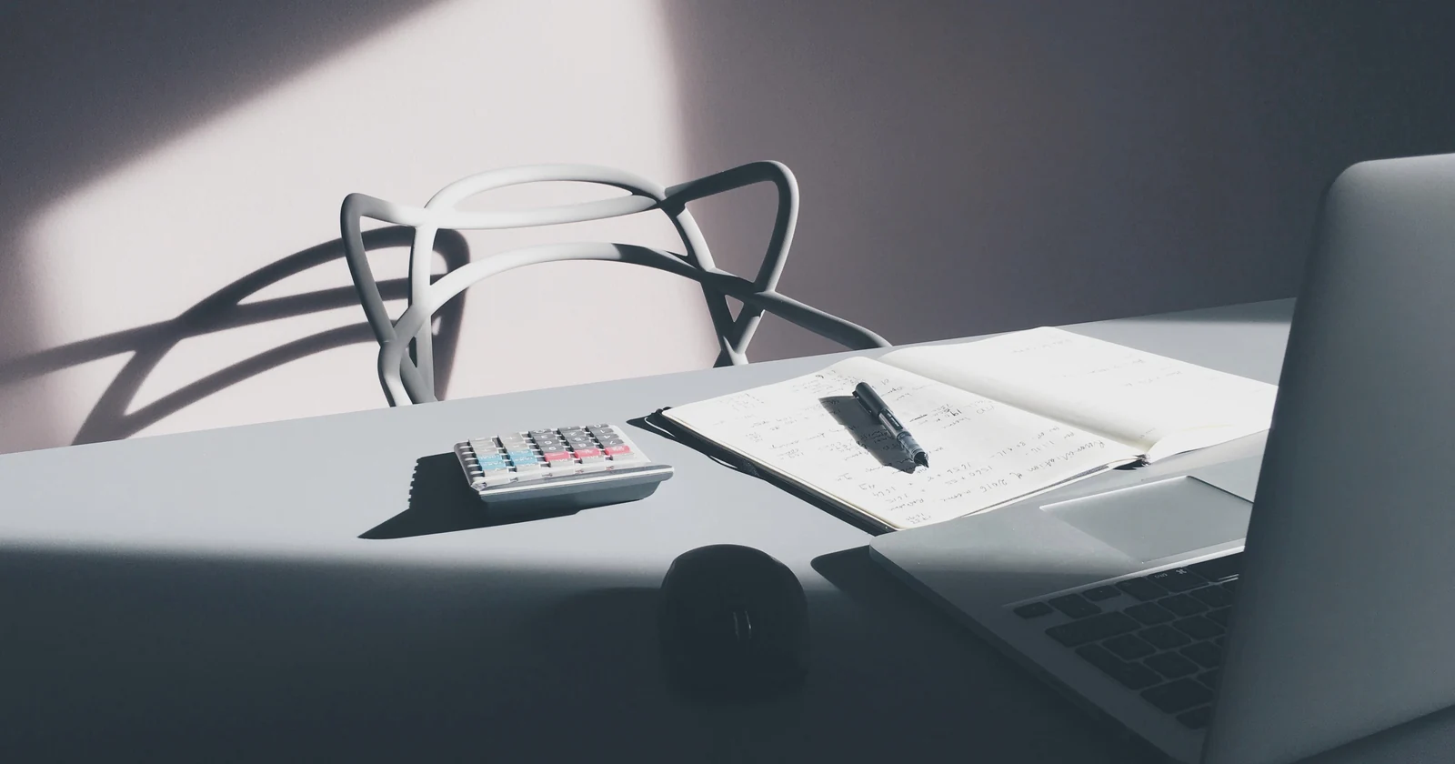 Laptop and calculator arranged on an office desk