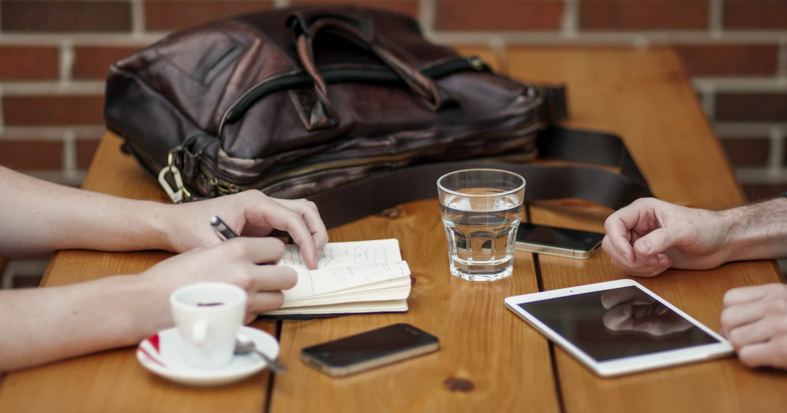 Colleagues reviewing notes and mobile devices during a meeting