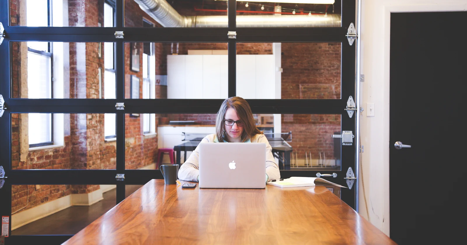Woman working on a laptop at a shared office table